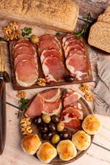 cold cuts table with assorted cheeses, Sardinian provolone and flavoured with oregano and olives, homemade bread with loin, ham, pork shoulder, bacon, salami, mortadella with nuts and a variety of col