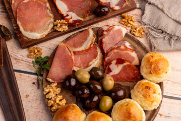 cold cuts table with assorted cheeses, Sardinian provolone and flavoured with oregano and olives, homemade bread with loin, ham, pork shoulder, bacon, salami, mortadella with nuts and a variety of col