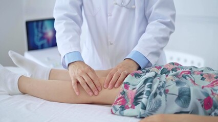 Doctor and kid patient. Orthopedist examining girl's knee in medical clinic. Medicine and health care