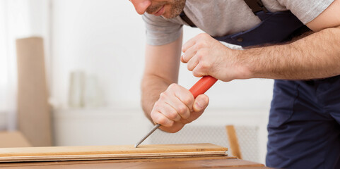 Carpenter Making Furniture Working With Wooden Board Indoor, Wearing Blue Coverall. Selective Focus, Empty Space