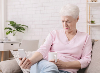 Hyperopia. Woman squinting and holding phone far from eyes, reading smartphone screen