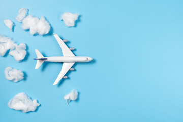Model airplane flying through cotton clouds
