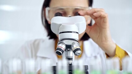 Woman scientist using microscope in laboratory. Microbiology science concept