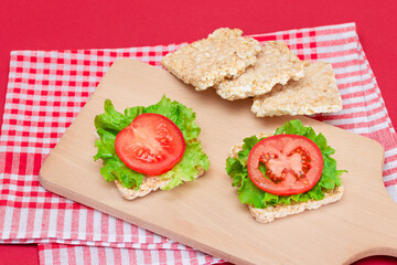 Rice Cake Sandwiches with Tomato and Lettuce on Wooden Cutting Board. Easy Breakfast. Diet Food. Quick and Healthy Sandwiches. Crispbread with Tasty Filling. Healthy Dietary Snack