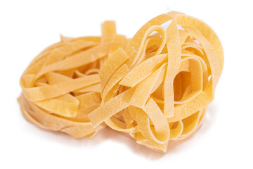 Two Classic Italian Raw Egg Fettuccine - Isolated on White Background. Dry Twisted Uncooked Pasta....