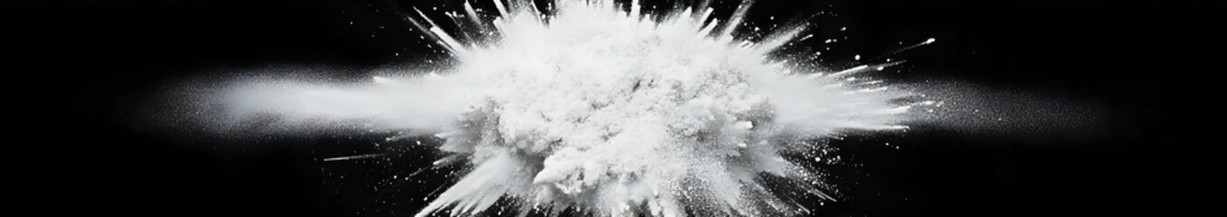 A dramatic explosion of white powder against a dark background, creating a striking visual effect.