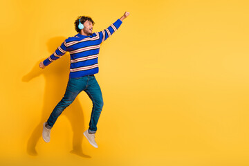 Full body photo of attractive young man headphones flying superman dressed stylish blue striped...