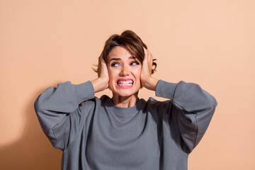 Photo portrait of attractive young woman cover ears annoying loud noise wear trendy gray clothes...