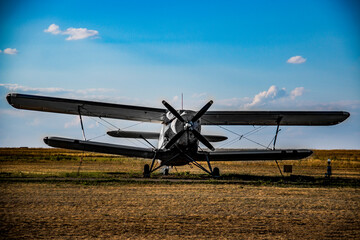 plane with propeller in front biplane stands in a field