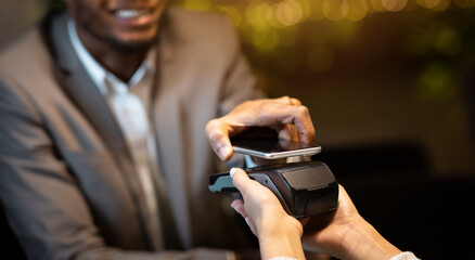 Contactless Payment System. Happy black businessman holding cellphone close to electronic payment...