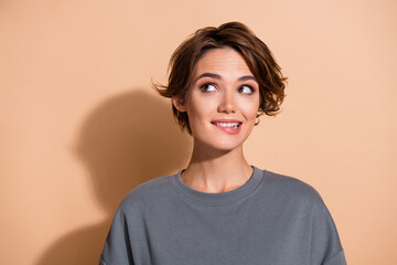 Photo portrait of lovely young lady look interested empty space bite lips dressed stylish gray...