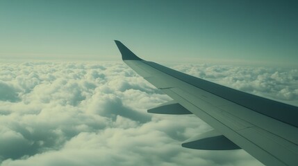 Obraz premium Airplane Wing Above Soft White Clouds