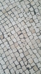 Calçamento com pedras formando textura abstrata.