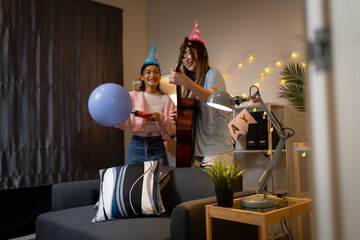 Fototapeta premium Two Asian women in room with Ciematic lighting celebrate important events such birthdays Christmas