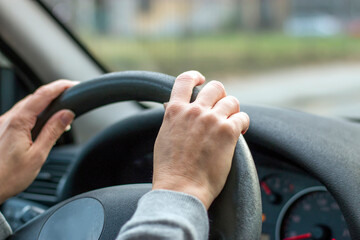 Woman hands holding steering wheel