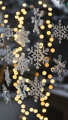 Festive winter decorations featuring sparkling acrylic snowflakes suspended above warm golden bokeh Christmas lights.