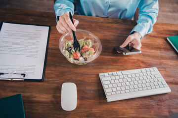 High angle view cropped photo of successful corporate worker lady eat salad hold phone wear shirt modern loft interior office indoors