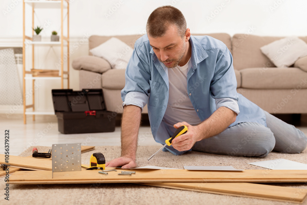 Poster middle-aged man installing furniture reading self-assembly manual furnishing house, sitting on floor