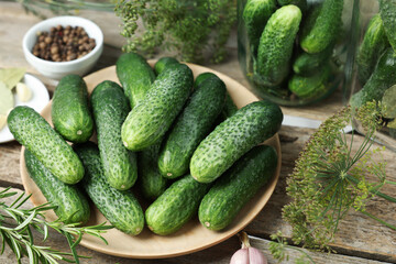 Fresh cucumbers, dill and spices on wooden table, closeup. Preparation for pickling