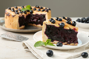 Slice of delicious homemade blueberry pie served on light table, closeup