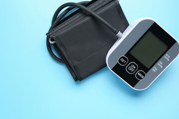Blood pressure measuring device on light blue background, top view