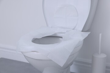 Toilet seat with paper tissues in bathroom