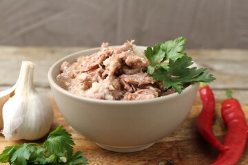 Canned meat in bowl and fresh products on table, closeup