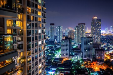 Obraz premium A high-rise luxury condominium with a stunning night view of the city, featuring illuminated balconies, spacious units, and luxury amenities.