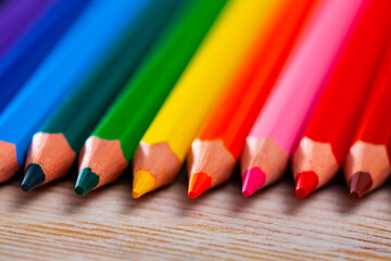 Variety of colorful pencils lying on wooden table. Creativity concept..