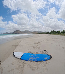 A blue surfing or peddle board at the beach