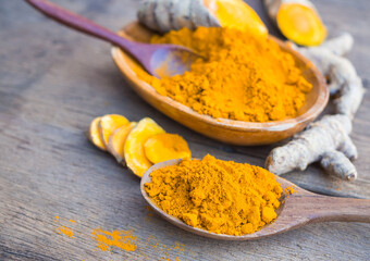 Turmeric powder in wooden spoon on old wooden table. herbal