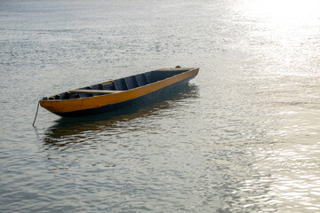 Small boat anchored on the lake. Wooden fisherman's boat.
