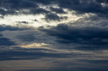Clouds hide the sun during sunset. Storm clouds.