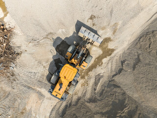 bulldozer on earthmoving at construction site, aerial view. © xiaoliangge