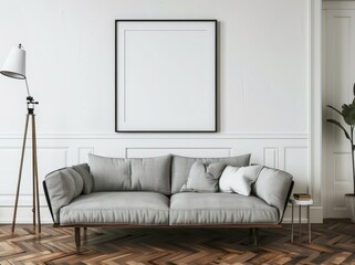 A modern living room with a gray sofa. a wooden floor. a white wall. and a large black frame