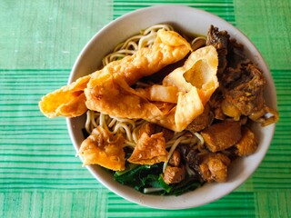 Mie Ayam, or Chicken Noodles, is one of the most popular foods in Indonesia. It consists of noodles, chicken pieces, and mustard greens, plus fried wonton. It's savory, salty, and a little sweet.