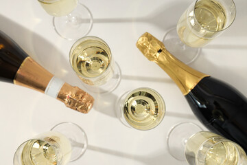 A bottle of champagne with glasses on a light background