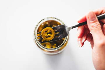 pickled jalapenos in clear glass jar shot from above, pantry staple ingredients