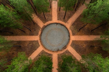 Fototapeta premium Aerial view of a circular stone path surrounded by pine trees.