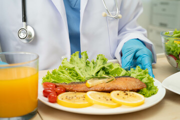 Asian Nutritionist holding healthy food for patient in hospital, nutrition and vitamin.