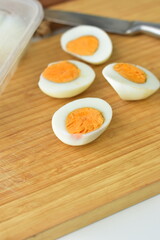 cut two pieces of omega boiled eggs served on a wooden cutting board