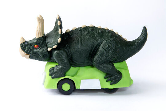 toy Triceratops car with wheels on a white background
