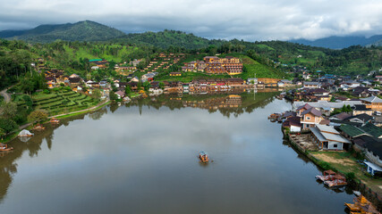 Fototapeta premium aerial view of hills and Chinese buildings in Ban Rak Thai Village and small raft tourist at Ban Rak Thai Resort, Mae Hong Son, Thailand