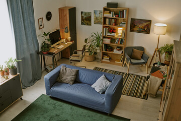 High angle shot of ample work zone with wooden furniture and huge number of book on shelves in modern living room