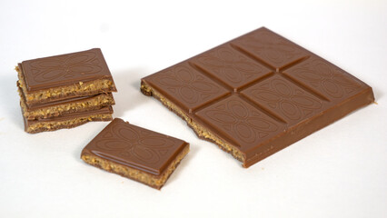 Milk chocolate bar filled with cookie dough caramel butter nuts filling with pieces stacked isolated on white background