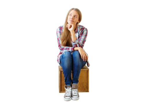 Young woman in casual attire sits on wooden box, thoughtful expression, isolated on white background. Concept of contemplation - Powered by Adobe