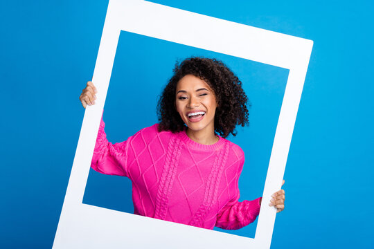Photo portrait of pretty young girl hold instant photo frame wear trendy pink outfit isolated on blue color background