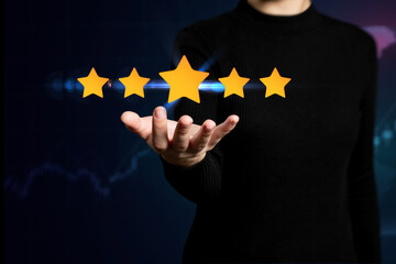 A person hand holding five stars icon, Goal, Growth, Investment concept, On stock market trading chart background