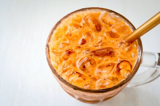 Cha nom Yen ,Thai Iced milk Tea, Traditional Thai tea with sweetened condensed, close up on white background