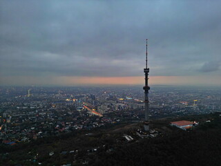 Obraz premium Koktobe TV tower on the hill after sunset. View of the city. Cloud cover. Autumn.